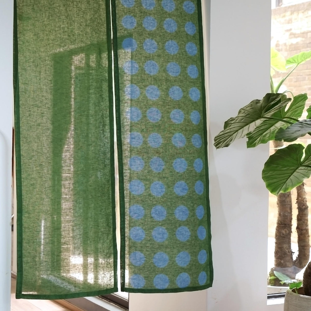 alternate angle of Polka Dot Linen Noren — Green / Dots hanging as a two-panel doorway curtain