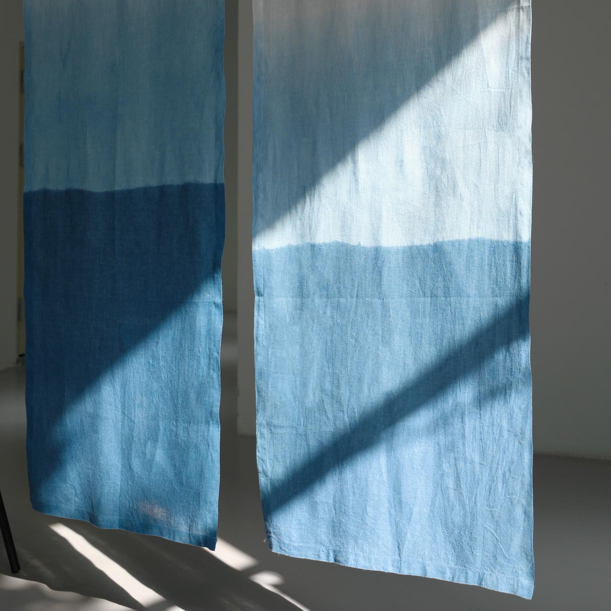 detail view of Soft Tone Noren — Mist Blue showing plant-dyed linen texture and pattern