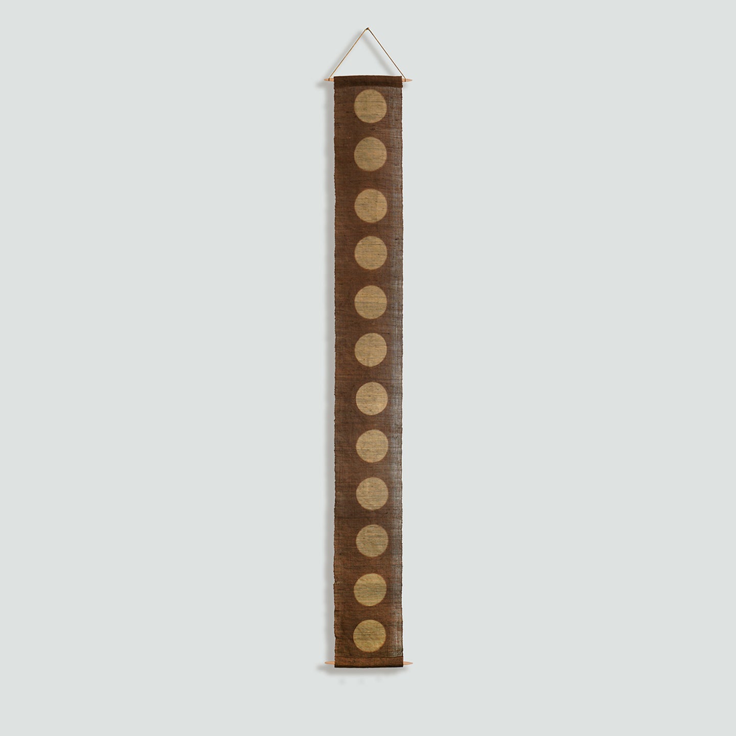 Narrow Ramie — Circles displayed vertically on a wall as a decorative textile banner