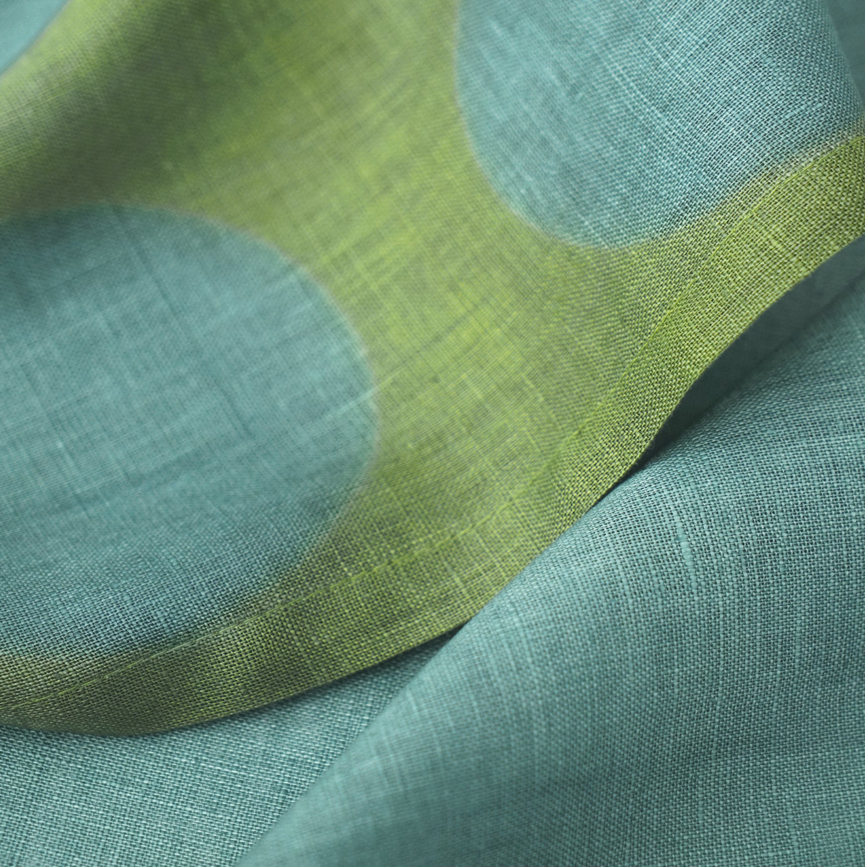 Hand dyed linen noren curtain in blue and green, hanging in a doorway as a room divider