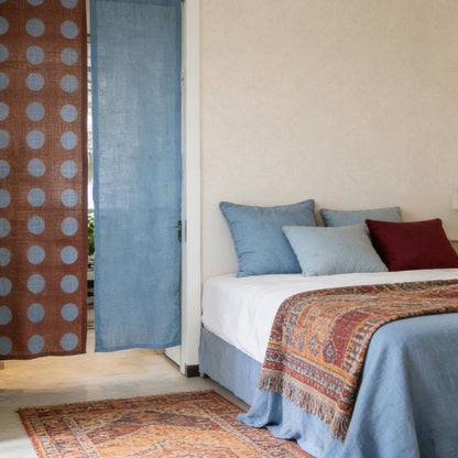alternate angle of Polka Dot Linen Noren — Rust / Blue hanging as a two-panel doorway curtain