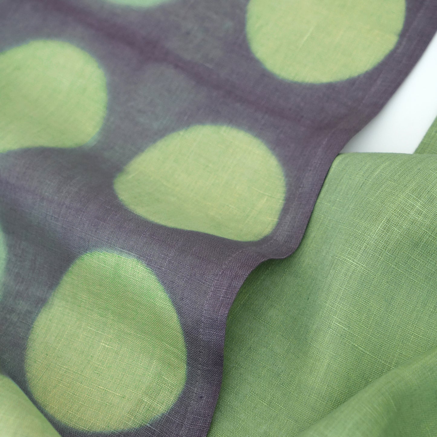Hand dyed linen noren curtain in purple and green, hanging in a doorway as a room divider