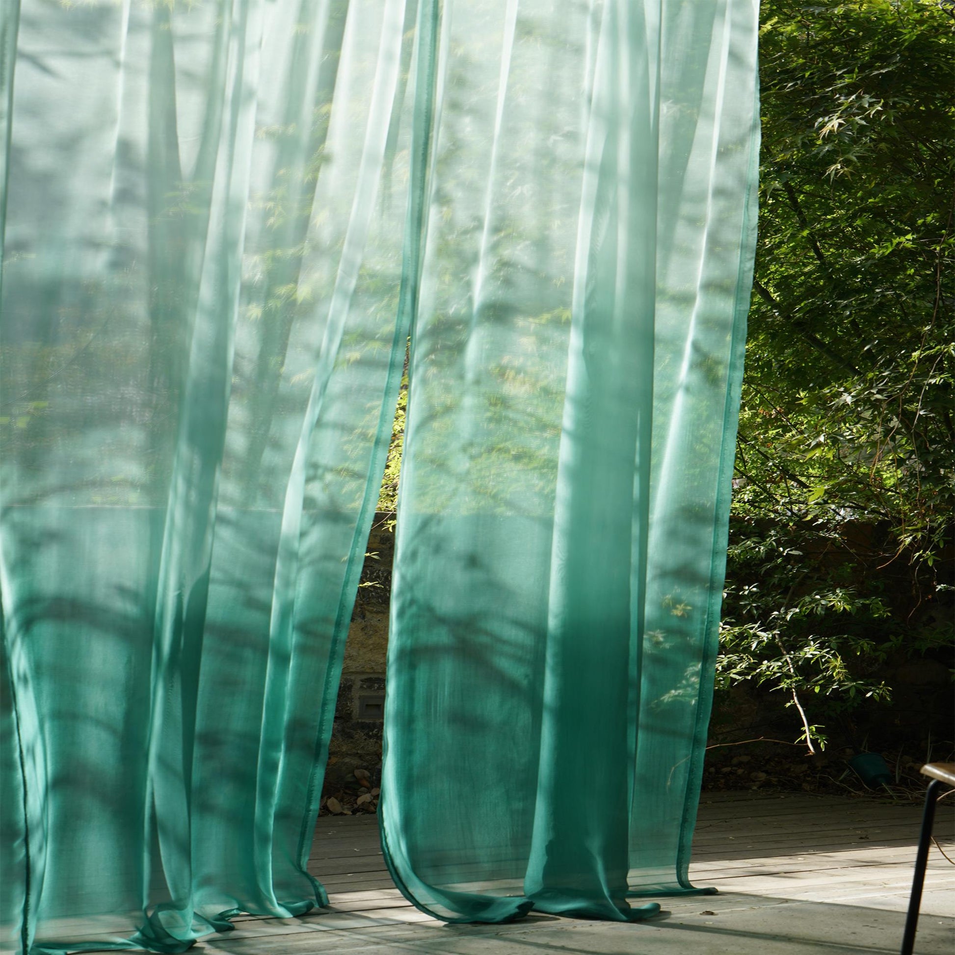 Sheer Curtain — Emerald Blue hung as window curtains in a bright room